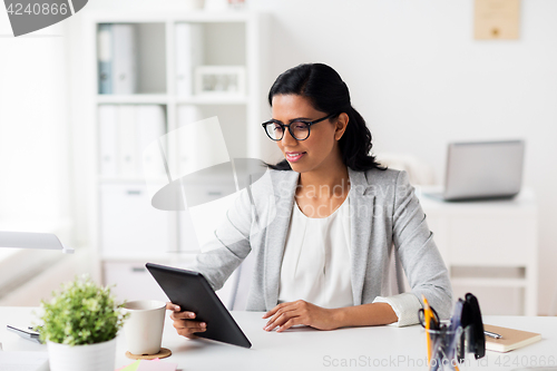 Image of smiling businesswoman with tablet pc at office