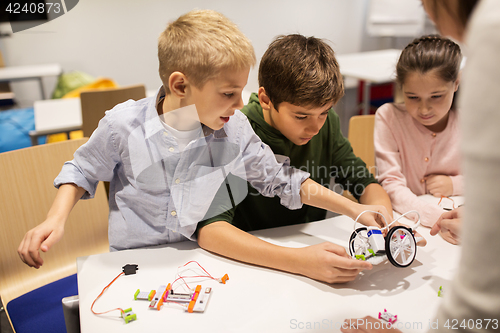 Image of happy children building robots at robotics school