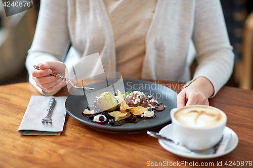 Image of woman eating ice cream dessert with coffee at cafe