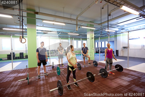 Image of group of people training with barbells in gym