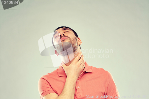 Image of man touching neck and suffering from throat pain