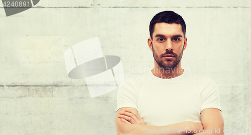 Image of young man with crossed arms over gray background