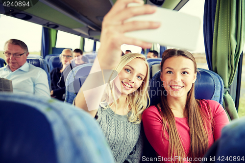 Image of women taking selfie by smartphone in travel bus