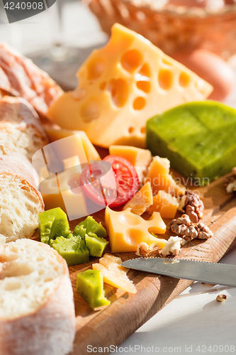 Image of The baguette and cheese on wooden background