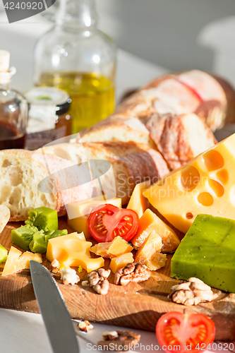 Image of The baguette and cheese on wooden background