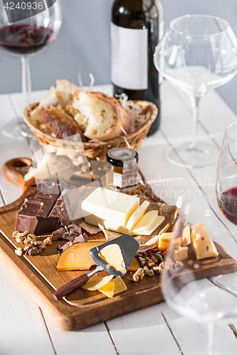 Image of Wine, baguette and cheese on wooden background