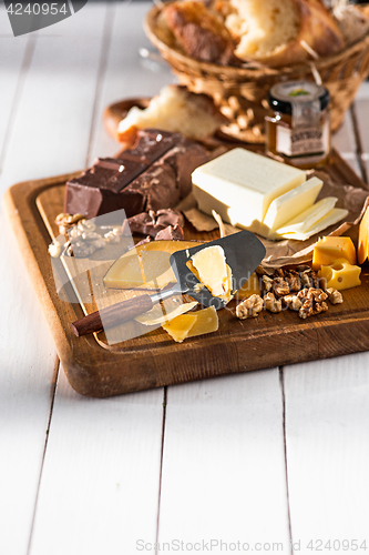 Image of The different kind of cheese and walnuts on wooden background