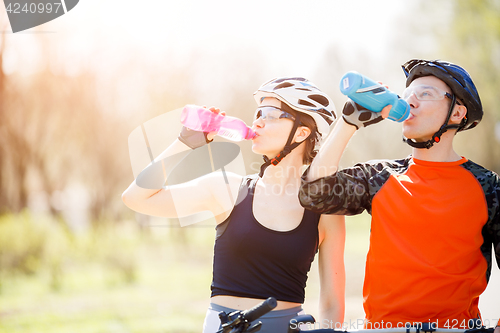 Image of Cyclists drink water from bottle