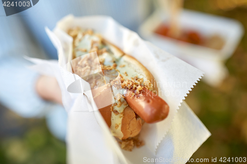 Image of close up of hand with hot dog