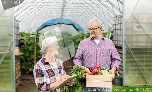 Image of senior couple with box of vegetables on farm