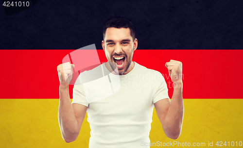 Image of angry man showing fists over german flag