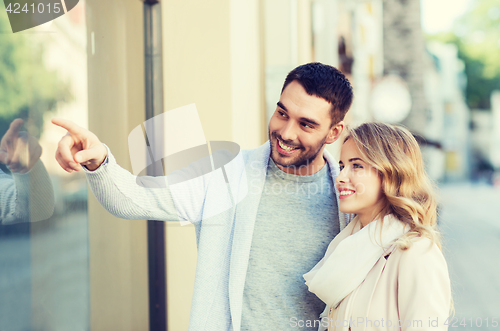 Image of happy couple shopping and looking at shop window