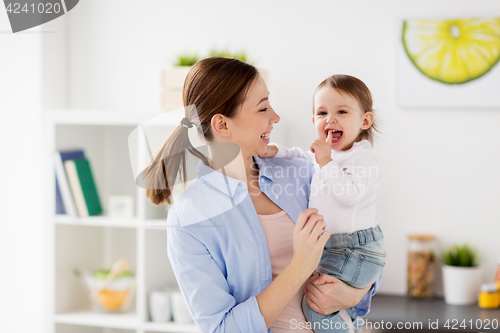 Image of happy mother and little baby girl at home kitchen