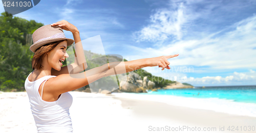 Image of happy young woman in hat on summer beach