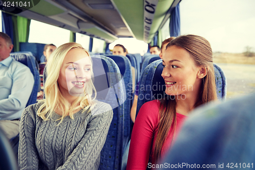 Image of happy young women talking in travel bus