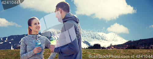 Image of smiling couple with bottles of water outdoors