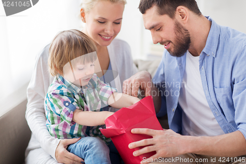 Image of happy family with birthday gift at home