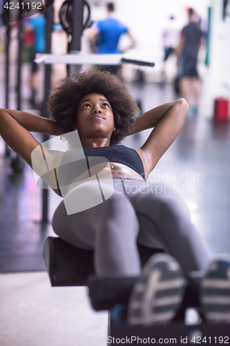 Image of black woman doing sit ups at the gym