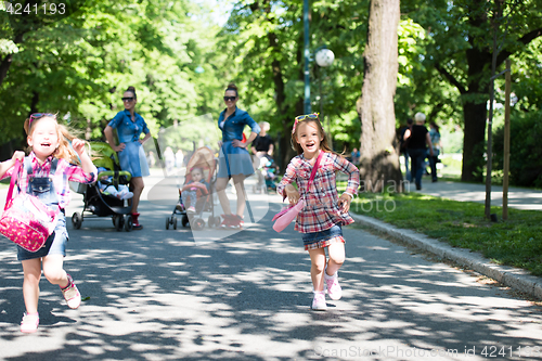 Image of twins mother with children  in city park