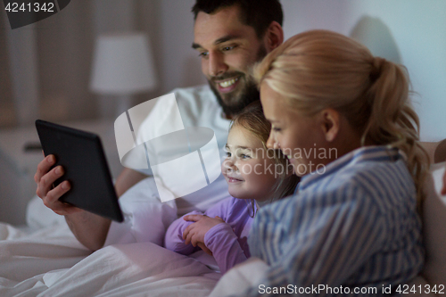 Image of happy family with tablet pc in bed at home