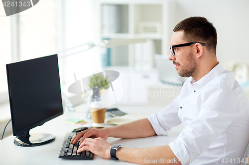 Image of businessman typing on computer keyboard at office