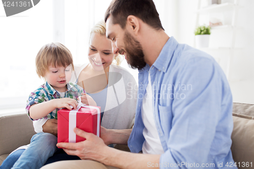 Image of happy family with birthday gift at home