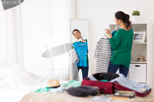 Image of woman packing travel bag at home or hotel room