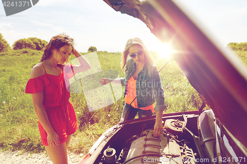 Image of women with open hood of broken car at countryside