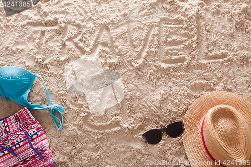 Image of Travel written in a sandy tropical beach