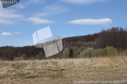 Image of Mountains and field in the early spring on a blue sky background