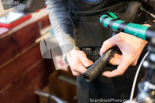 Image of Man fixing bicycle in garage