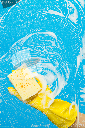 Image of Cleaner with sponge cleaning window