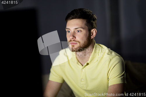 Image of young man watching tv at night