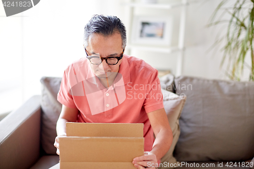 Image of man opening parcel box at home