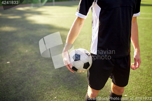 Image of soccer player with ball on football field