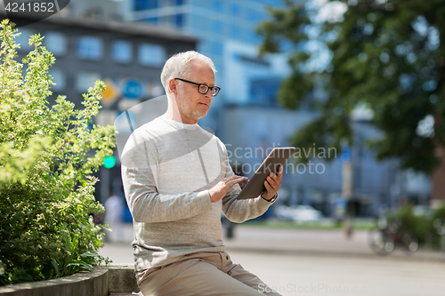 Image of senior man with tablet pc on city street