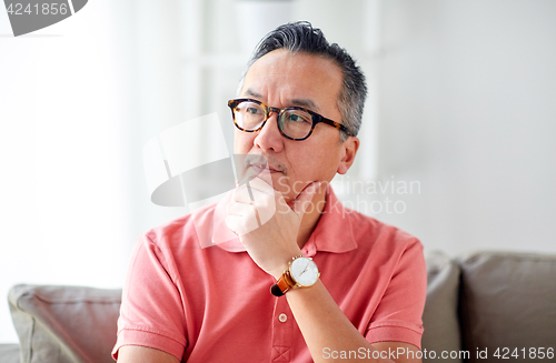 Image of asian man thinking at home