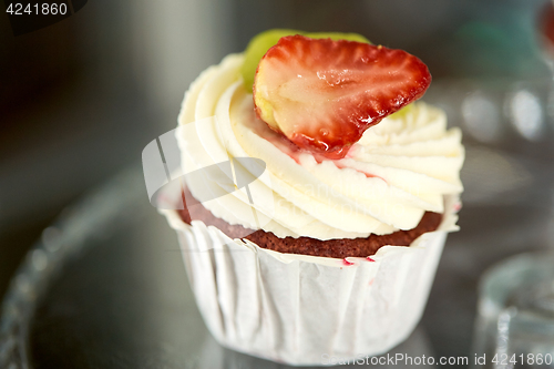 Image of close up of cupcake with cream and strawberry