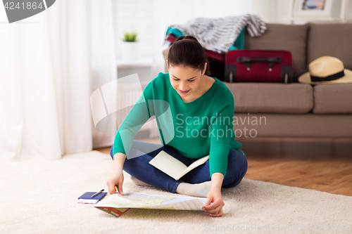 Image of woman with map planning her travel at home
