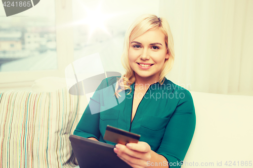 Image of happy woman with tablet pc and credit card