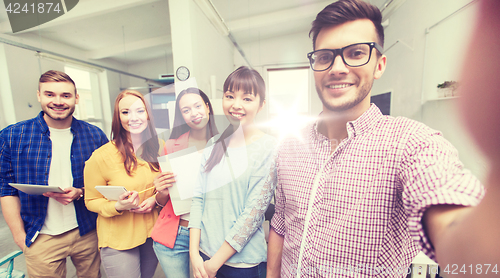 Image of creative business team taking selfie at office