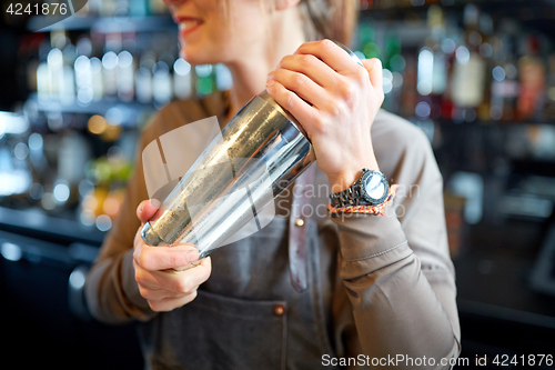 Image of close up of bartender with cocktail shaker at bar