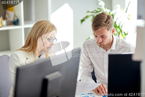 Image of business team discussing papers at office table