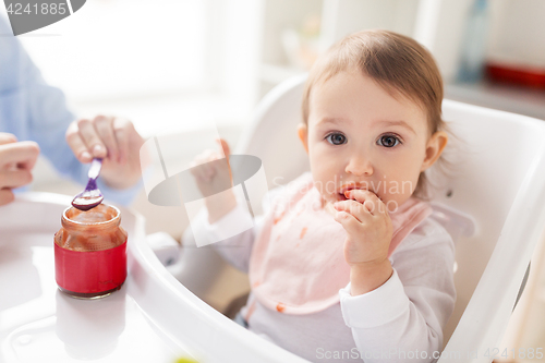 Image of mother feeding baby with puree at home