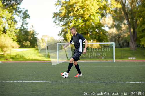 Image of soccer player playing with ball on football field