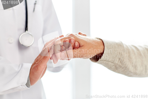 Image of close up of doctor holding old man hand