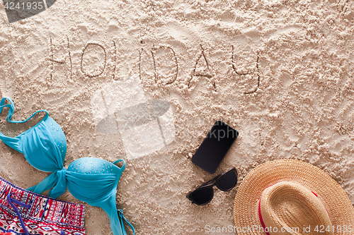 Image of Holiday written in a sandy tropical beach