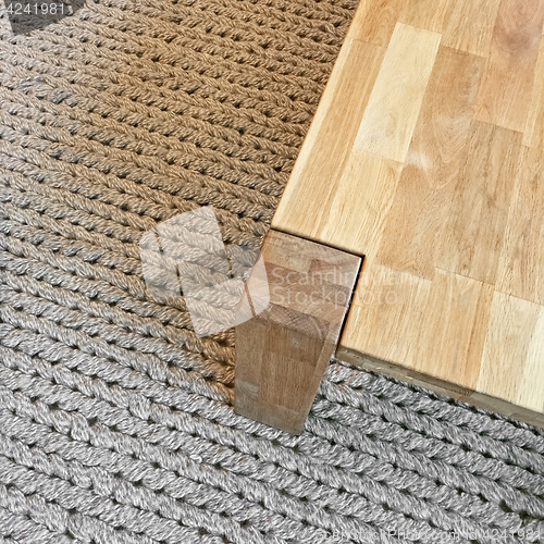 Image of Wooden table on gray knitted carpet