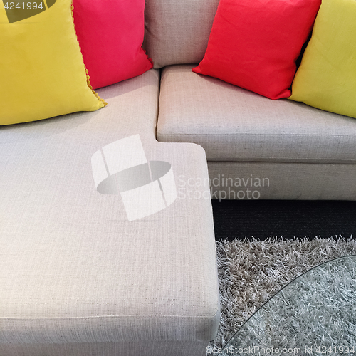 Image of Red and yellow cushions on gray corner sofa