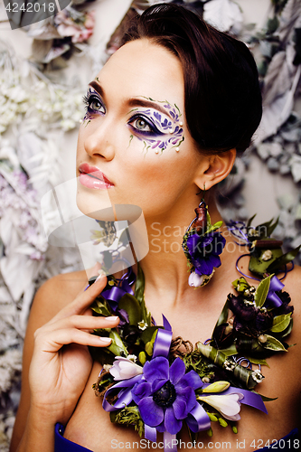 Image of floral face art with anemone in jewelry, sensual young brunette 